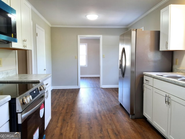 1014 Walnut St, Louisville, GA 30434 - kitchen with electric range, black microwave, dark wood finished floors, white cabinetry, and ornamental molding