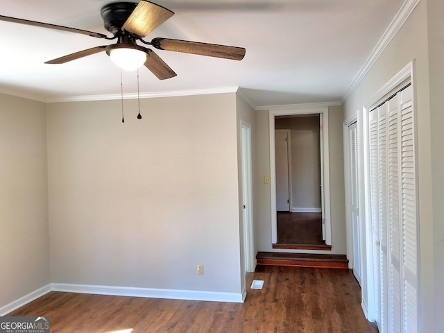 interior space featuring dark wood-style floors, ornamental molding, and baseboards