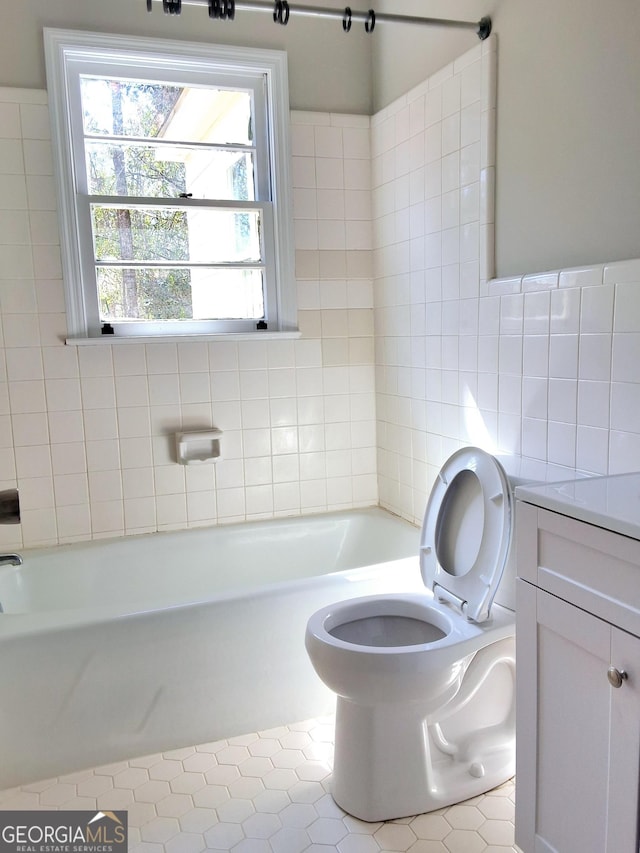 bathroom featuring toilet, shower / washtub combination, tile walls, and vanity