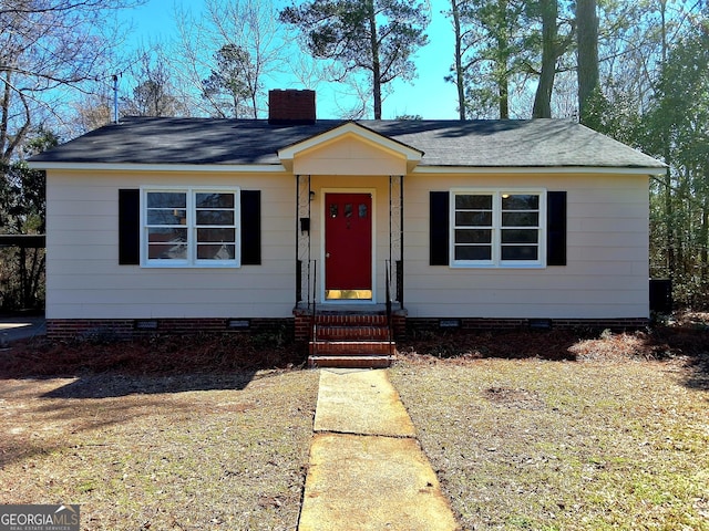 view of front of house featuring entry steps, crawl space, roof with shingles, and a chimney