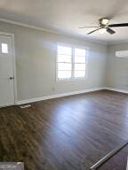 foyer with ceiling fan, crown molding, baseboards, and dark wood-type flooring