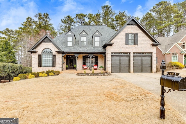 view of front of property featuring driveway, a shingled roof, an attached garage, and brick siding