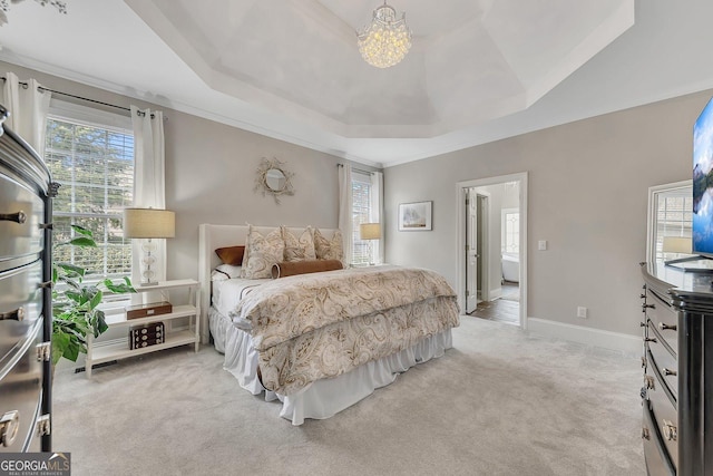 bedroom with a tray ceiling, light colored carpet, baseboards, and multiple windows