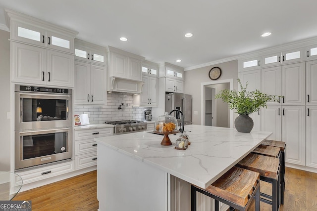 kitchen with glass insert cabinets, white cabinets, and appliances with stainless steel finishes