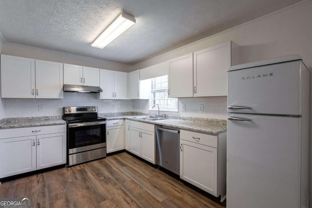 kitchen with white cabinets, under cabinet range hood, stainless steel appliances, and a sink