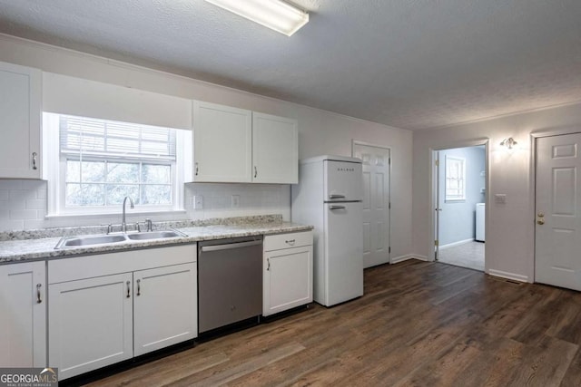 kitchen with a sink, white cabinetry, dishwasher, and freestanding refrigerator