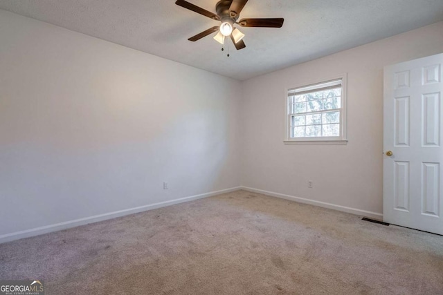 unfurnished room with light colored carpet, visible vents, a ceiling fan, a textured ceiling, and baseboards