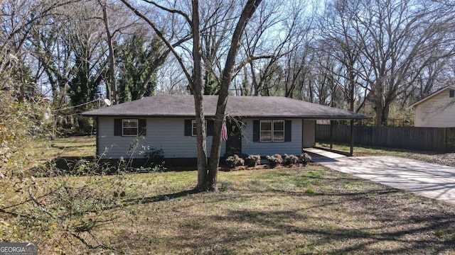 view of front facade with driveway, fence, a front lawn, and an attached carport