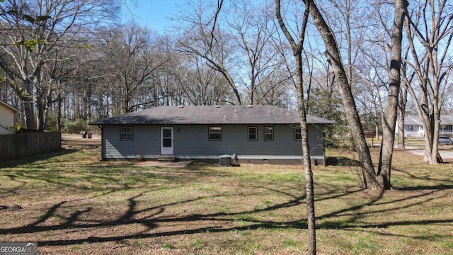 rear view of house featuring a yard, crawl space, and fence