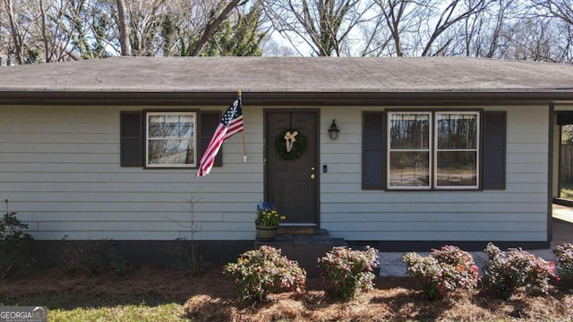 ranch-style home with roof with shingles