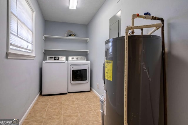 laundry area featuring laundry area, light tile patterned floors, baseboards, washer and clothes dryer, and water heater