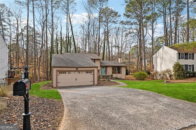 view of front of property featuring a chimney, aphalt driveway, a front lawn, and an attached garage