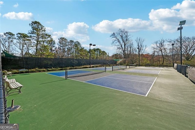 view of tennis court featuring fence