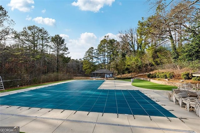 view of pool with a covered pool, fence, and a patio