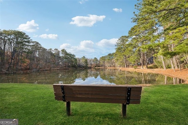 view of home's community with a water view and a yard