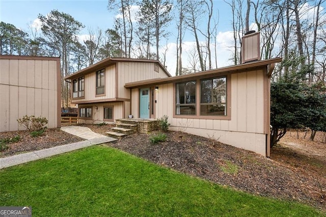 tri-level home featuring a chimney and a front yard