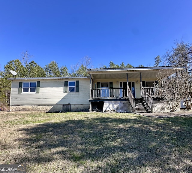 rear view of property with crawl space, covered porch, a yard, and stairs