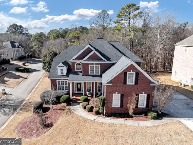 traditional-style house with brick siding and roof with shingles