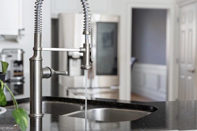 interior details with dark stone countertops and white cabinets