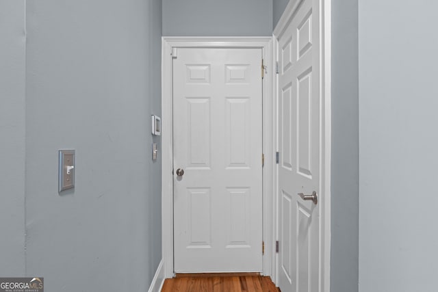 doorway featuring baseboards and wood finished floors