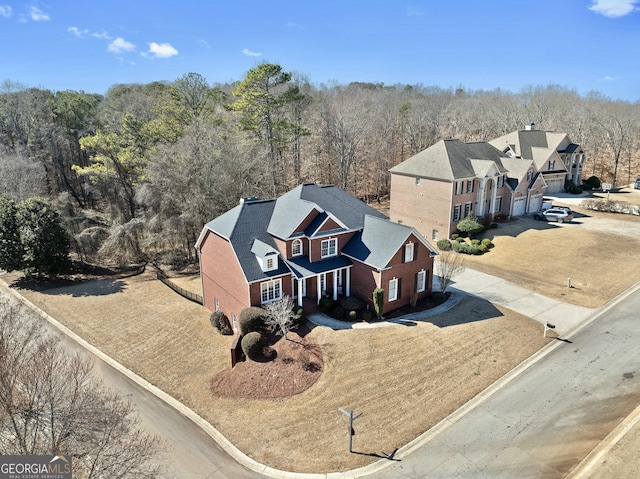birds eye view of property featuring a forest view