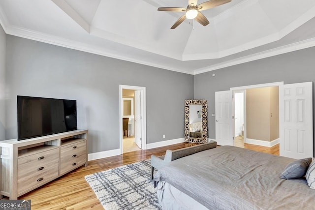 bedroom with ceiling fan, connected bathroom, baseboards, light wood-type flooring, and a tray ceiling