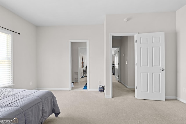 bedroom with baseboards and light colored carpet
