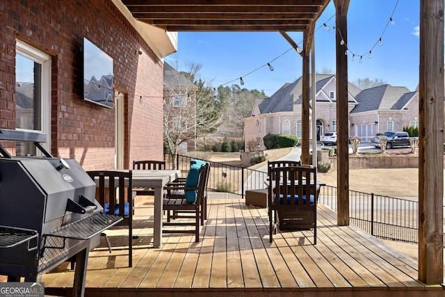 wooden deck featuring grilling area, a residential view, and outdoor dining area