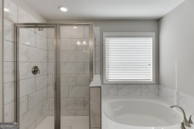 full bathroom featuring a garden tub and a shower stall