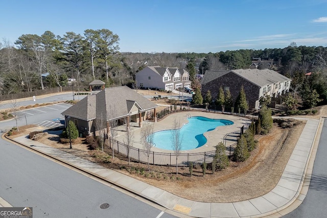 community pool with a residential view, fence, and a patio