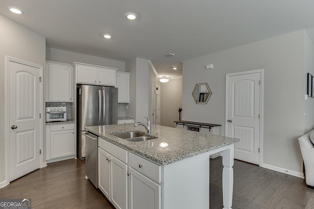 kitchen featuring light stone counters, white cabinetry, a sink, an island with sink, and dishwasher