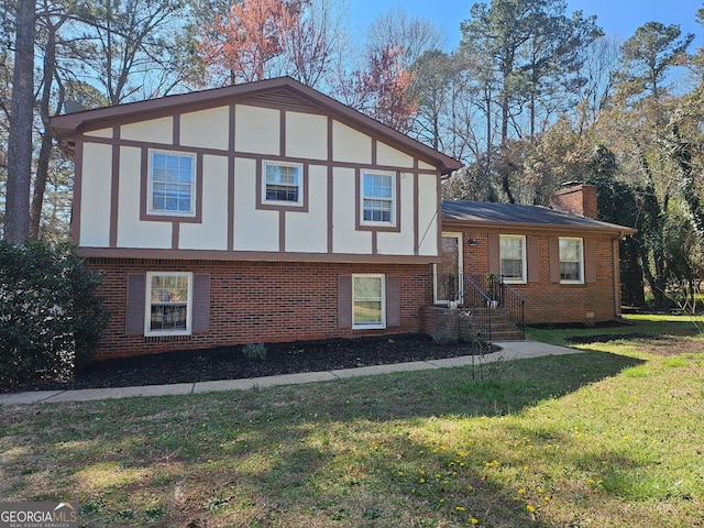 view of front facade with brick siding, stucco siding, a chimney, and a front lawn