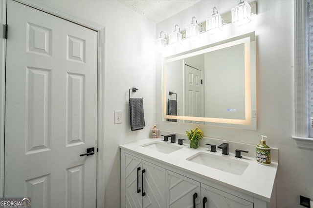 bathroom featuring double vanity, a textured ceiling, and a sink