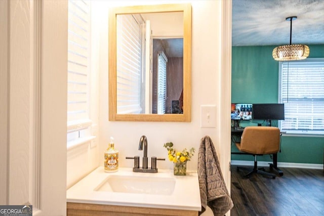 bathroom with baseboards, a sink, and wood finished floors