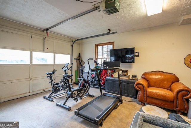 exercise room featuring a garage and a textured ceiling