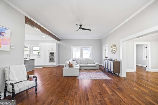 living room with dark wood-style floors, crown molding, and baseboards