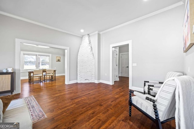 sitting room with dark wood-style flooring, crown molding, and baseboards