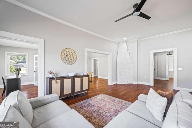 living room with dark wood-style floors, crown molding, baseboards, and a ceiling fan