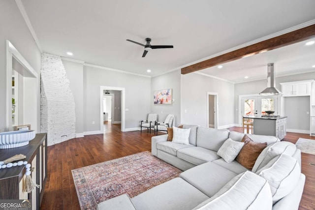 living area with ceiling fan, ornamental molding, dark wood finished floors, and baseboards