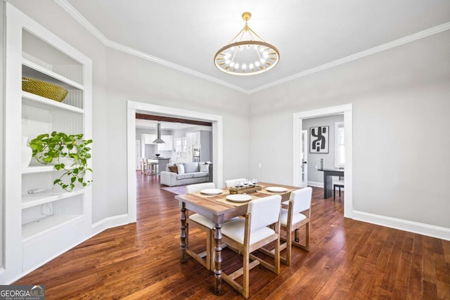 dining area featuring ornamental molding, dark wood-style flooring, a chandelier, and baseboards