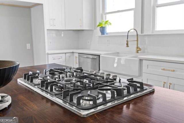 room details featuring white cabinetry, appliances with stainless steel finishes, light countertops, and a sink