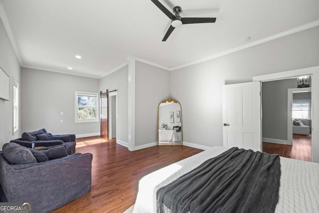 bedroom with a barn door, multiple windows, baseboards, and dark wood finished floors