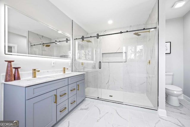 bathroom with double vanity, marble finish floor, a marble finish shower, and a sink