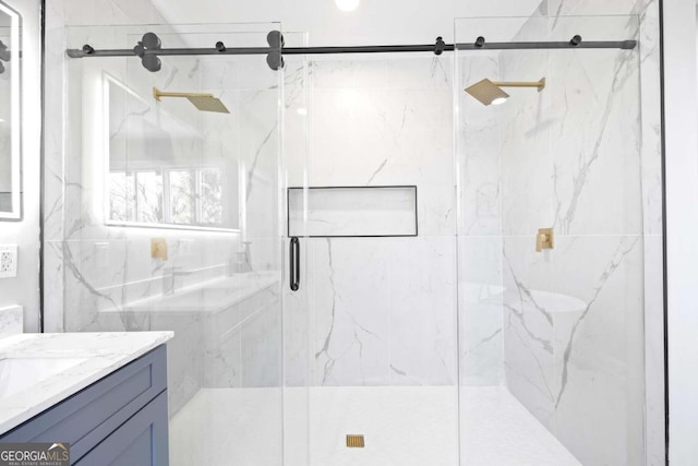 full bath featuring a marble finish shower and vanity