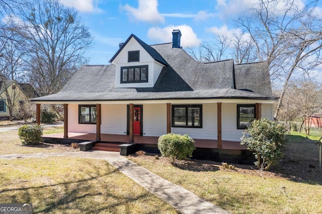 country-style home with a porch, a front yard, roof with shingles, and a chimney