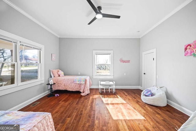 bedroom featuring wood finished floors, a ceiling fan, visible vents, baseboards, and ornamental molding