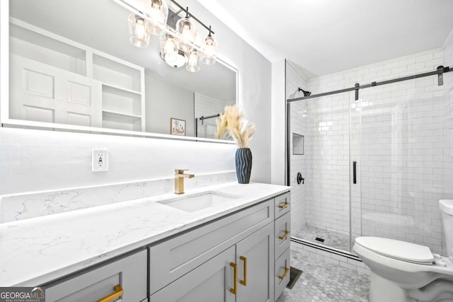 bathroom with toilet, a shower stall, and vanity