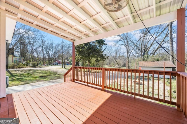 wooden terrace with ceiling fan and a lawn