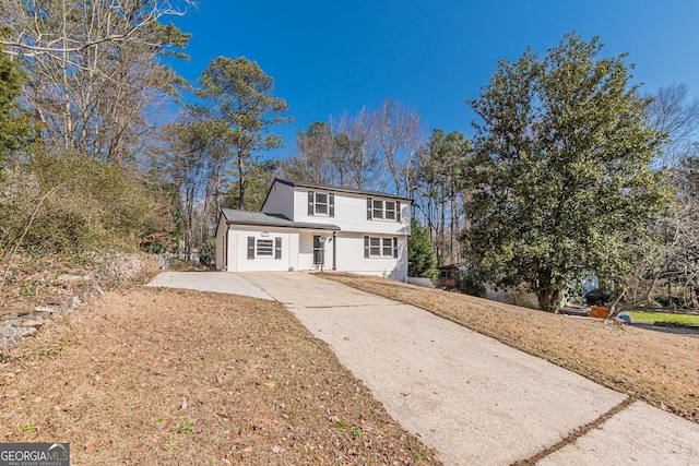 view of front facade featuring driveway and a front yard