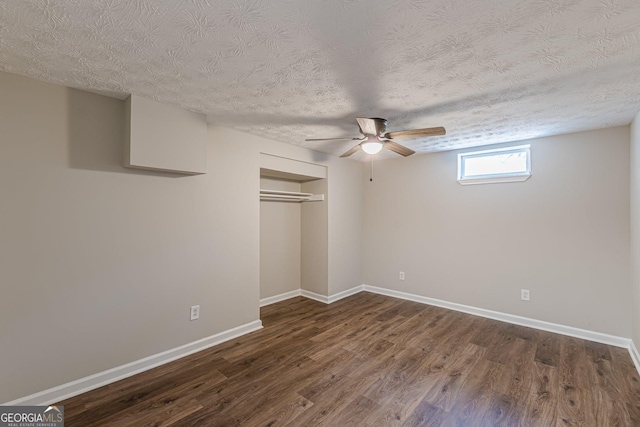 unfurnished bedroom with a closet, dark wood-style flooring, a textured ceiling, and baseboards